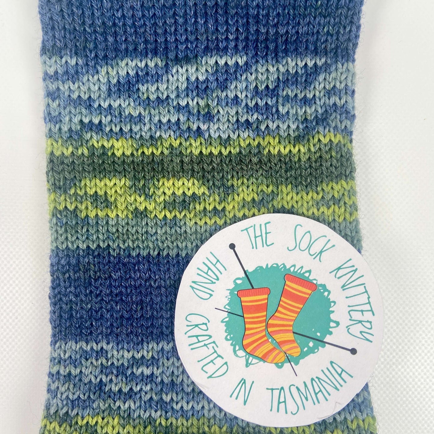 sample of knitted sock yarn in blue and green shades - The Sock Knittery