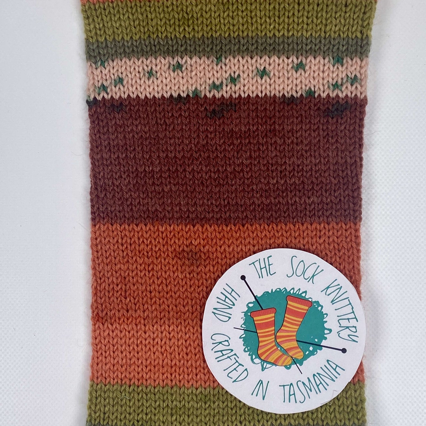 sample of sock yarn in copper shades, green shades and cream - The Sock Knittery